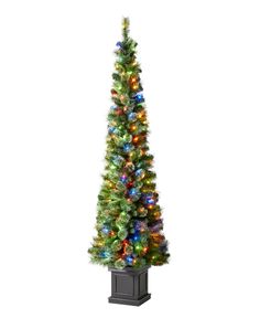 an artificial christmas tree with multi - colored lights on it's base, in a black planter