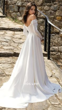 a woman in a white wedding dress is standing on some steps and posing for the camera