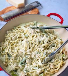 a pan filled with pasta and chicken on top of a table