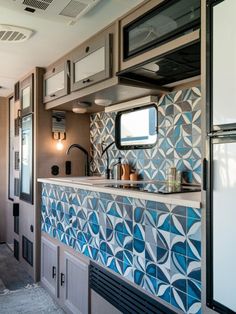 a kitchen with blue and white tiles on the wall