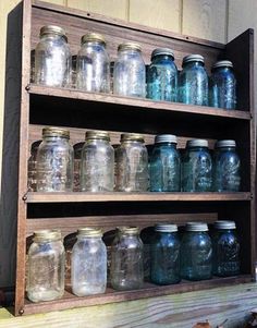 an old wooden shelf filled with mason jars