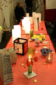 the table is set up with candles and paper bags on it for people to sit down