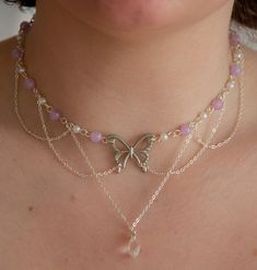 This necklace features delicate pastel purple beads, lustrous pearls, and draped chains, creating a layered, fairy and ethereal look. In the heart of this necklace, a captivating butterfly pendant and a sparkling clear crystal pendant add a touch of timeless beauty.  The layers of draped chains add depth and dimension to the necklace, allowing it to rest gracefully against your neckline, accentuating your natural beauty. The delicate nature of this piece ensures it is suitable for any occasion, from casual outings to formal events, making it a versatile addition to your jewellery collection. Elevate your style with this exquisite accessory, effortlessly blending sophistication with a touch of enchantment.  The pastel purple beads interspersed between the pearls create a harmonious colour p Ethereal Jewelry Necklaces, Crystal Beads Necklace, Ethereal Fairy, Necklace Casual, Ethereal Jewelry, Beaded Butterfly, Pretty Jewelry Necklaces, Casual Necklaces, Layered Chain Necklace