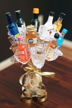 a vase filled with lots of bottles on top of a wooden table