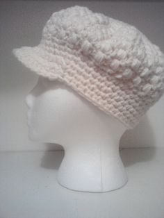 a white crocheted hat on a mannequin head