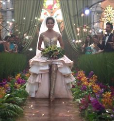 a woman in a wedding dress walking down a runway