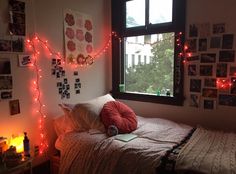 a bedroom with lights strung all over the wall and on the window sill above the bed