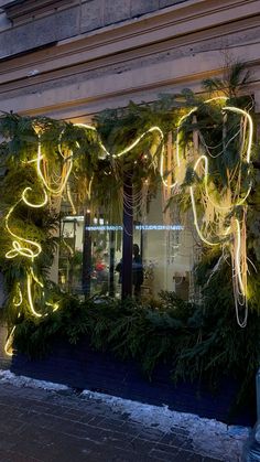 a store front decorated with christmas lights and greenery