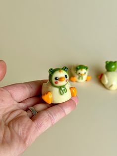 a hand is holding three small toy animals