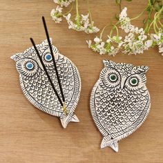 two owl shaped chopsticks sitting on top of a wooden table