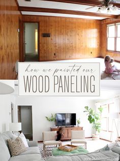 a living room filled with furniture and a sign that says how we painted our wood paneling