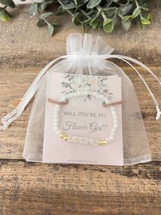 a small gift bag with a flower girl bracelet on it