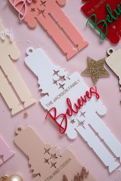 many different types of paper cutouts on a pink surface with gold and silver decorations