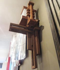 a wooden cross hanging from the side of a wall next to a mirror on a wall