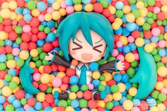 an action figure is surrounded by balls in a ball pit with blue hair and green eyes