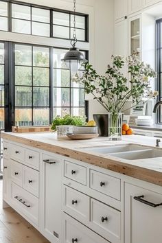 a kitchen with white cabinets and wooden counter tops next to an open doored window