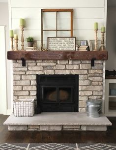 a living room with a fire place and some candles on top of the mantel