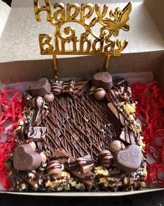 a birthday cake in a box with chocolates on it