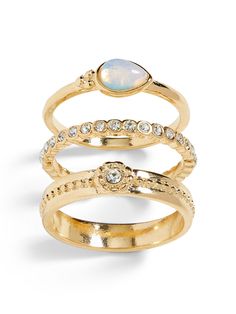 three gold rings with opal and diamonds on each one, set against a white background