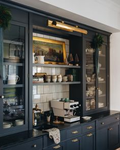 a kitchen with black cabinets and gold trim