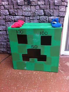 a cardboard box made to look like a minecraft creeper with the number 50 on it