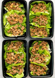 four black trays filled with lettuce covered in meat