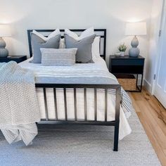 a bedroom with white walls and gray bedding