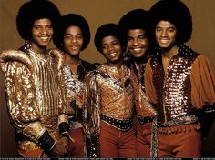 the jacksons posing for a photo in their gold outfits