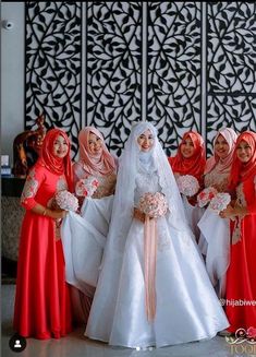 four women in red and white dresses posing for a photo with one woman wearing a veil