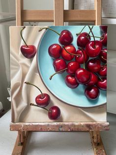 a painting of cherries on a blue plate