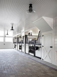 the inside of a horse barn with white walls and doors