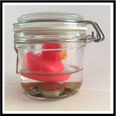 a glass jar filled with coins and a red rubber duck