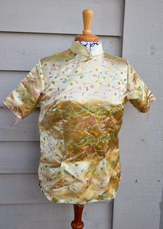 a mannequin wearing a gold shirt with sprinkles on it