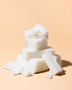 several pieces of white soap stacked on top of each other in front of a pink background