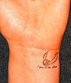 a woman's wrist with a small tattoo on it