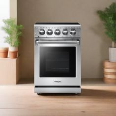 a silver stove top oven sitting on top of a wooden counter next to potted plants