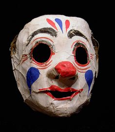 an old mask with red, white and blue paint on it