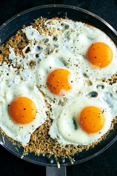 three fried eggs are in a pan on the stove top, ready to be cooked