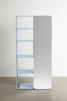 a white and blue book shelf sitting on top of a floor next to a wall