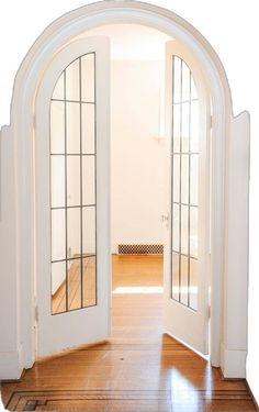 an open door leading to another room with wood floors and white walls, in front of a wooden floor