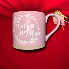 a pink coffee mug with i love you mom written on it