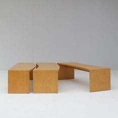 two wooden benches sitting next to each other on a white surface