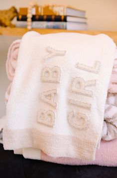 towels stacked on top of each other with the word baby written on them in white