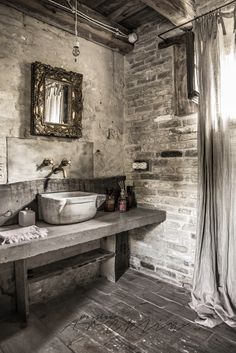 a rustic bathroom with stone walls and wood flooring is pictured in black and white