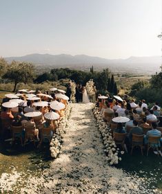 an outdoor ceremony with tables and umbrellas