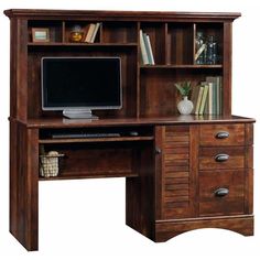 a wooden desk with a computer monitor and drawers