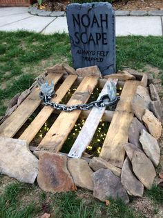 a wooden pallet with chains attached to it sitting in the grass next to a grave