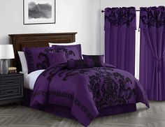 a bed with purple and black comforters in a room