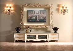 an ornate white entertainment center in a living room with chandeliers on the wall