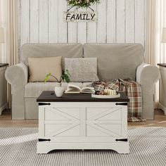 a living room with a couch, table and chair in front of a wooden wall